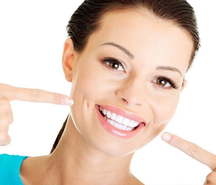 Woman pointing at her teeth and smiling